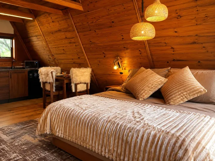 Cama sob o telhado em A, com luminárias de palha