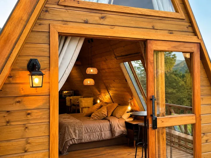 O quarto visto do deck, pela porta de vidro do chalé